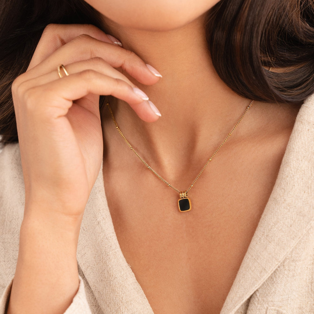 Selina - Collar de oro con gema oscura.